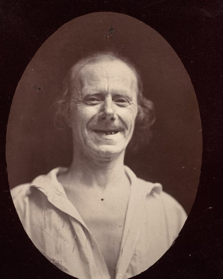 Nineteenth-century photograph of an older man laughing, with visible creases around his eyes